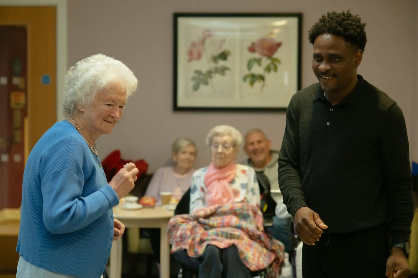 An older person being supported by a family carer in a home setting — representing the care-need context that drives both Attendance Allowance and NHS CHC eligibility.