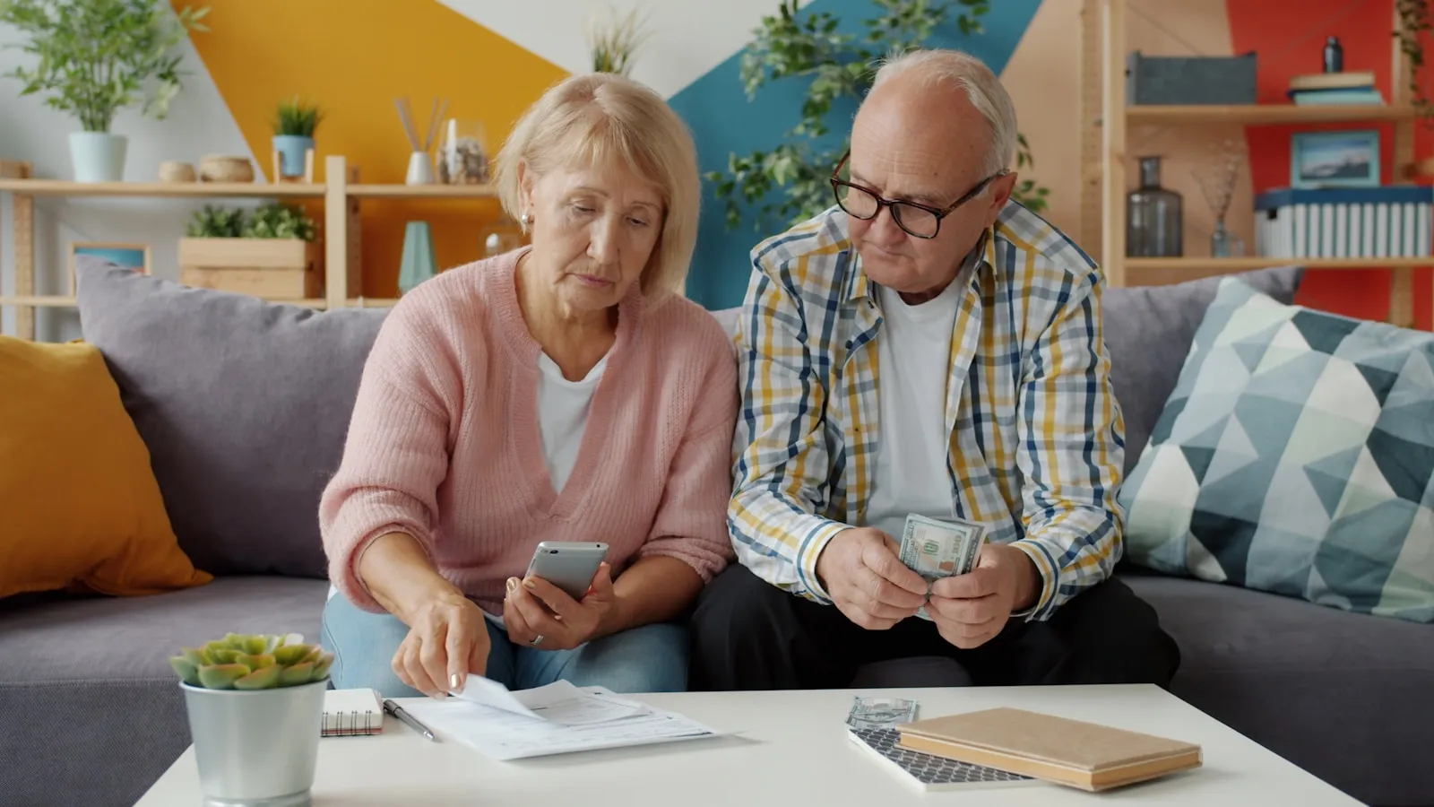 An older couple sitting in a garden with their adult child, going through paperwork together — the family scene behind every Attendance Allowance claim.