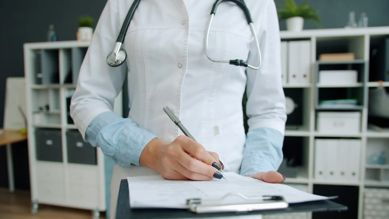 A healthcare professional ticking boxes on an NHS-style assessment form on a clipboard — the CHC Checklist scores 11 care domains as A, B or C.