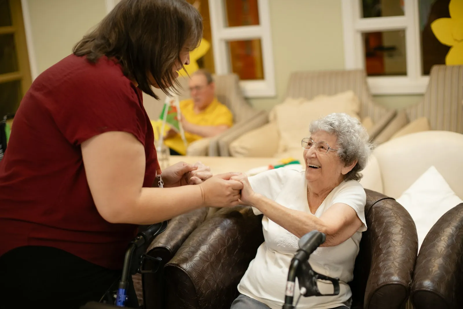 A home care worker assisting an older woman using a walker — the kind of mobility-support visit at the core of CQC-regulated domiciliary care in the UK in 2026.