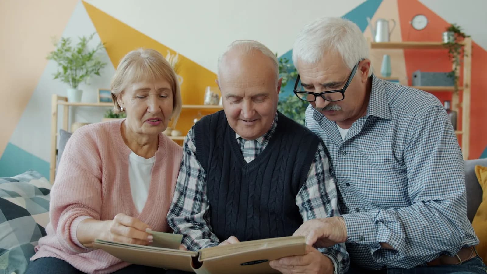 Adult children and an older parent sitting at a kitchen table reviewing financial paperwork together — the family decision that often follows a council letter offering a Deferred Payment Agreement.