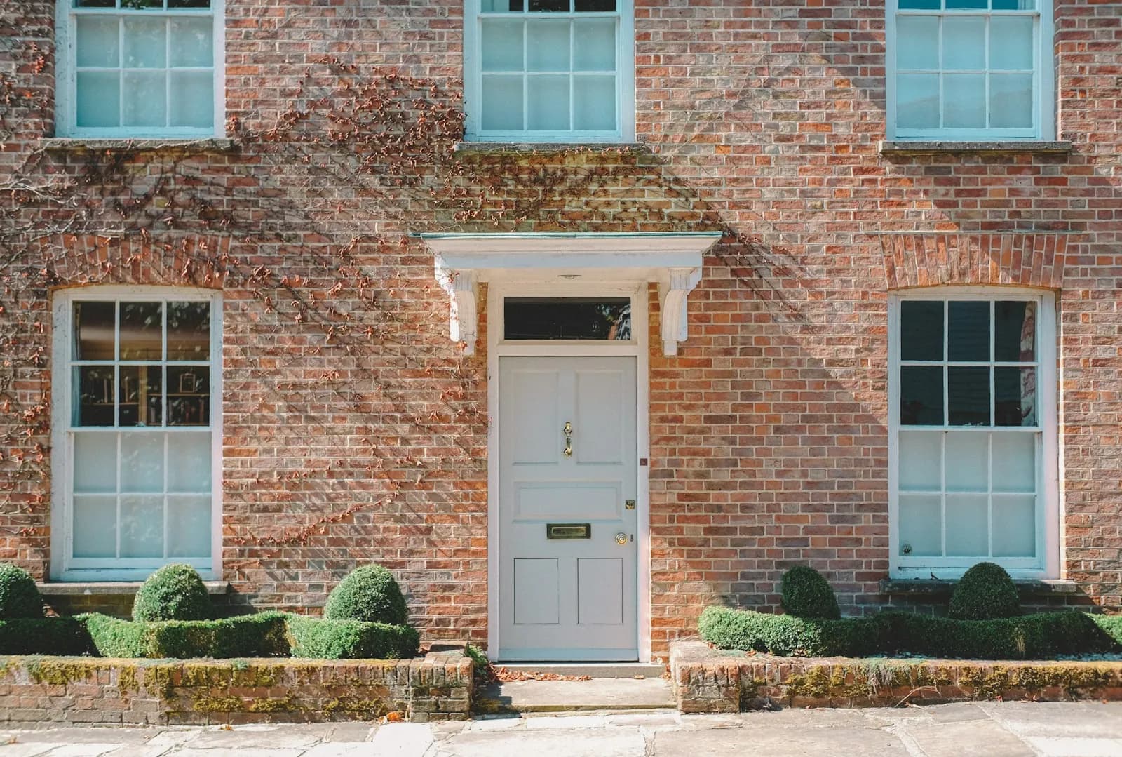A traditional UK family home with a painted front door and small garden — the asset that secures a Deferred Payment Agreement and the property the family will need to sell to discharge the debt.