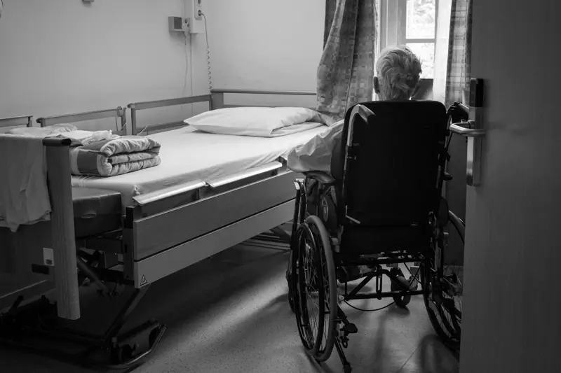 An older patient being supported by a family member while being discharged from hospital, representing the family experience of NHS hospital discharge.