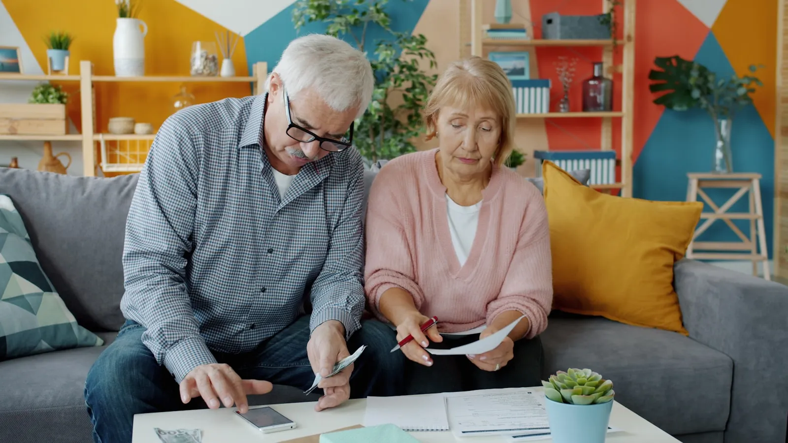 An older person looking carefully at a document at a kitchen table, with a family member seated nearby — the moment families realise capacity may already be in decline and the LPA window is closing.