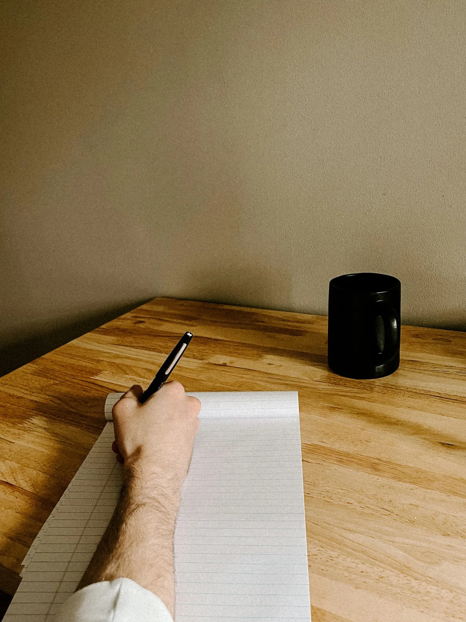 A family member at a kitchen table drafting a Subject Access Request letter, with a printed UK GDPR reference and the data subject's NHS number visible — the typical setup for a DIY SAR filing.