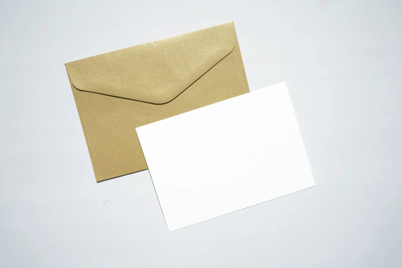 A close-up of an unopened brown DWP envelope on a kitchen table, with reading glasses and a calendar nearby — the everyday scene that opens every PIP Mandatory Reconsideration.