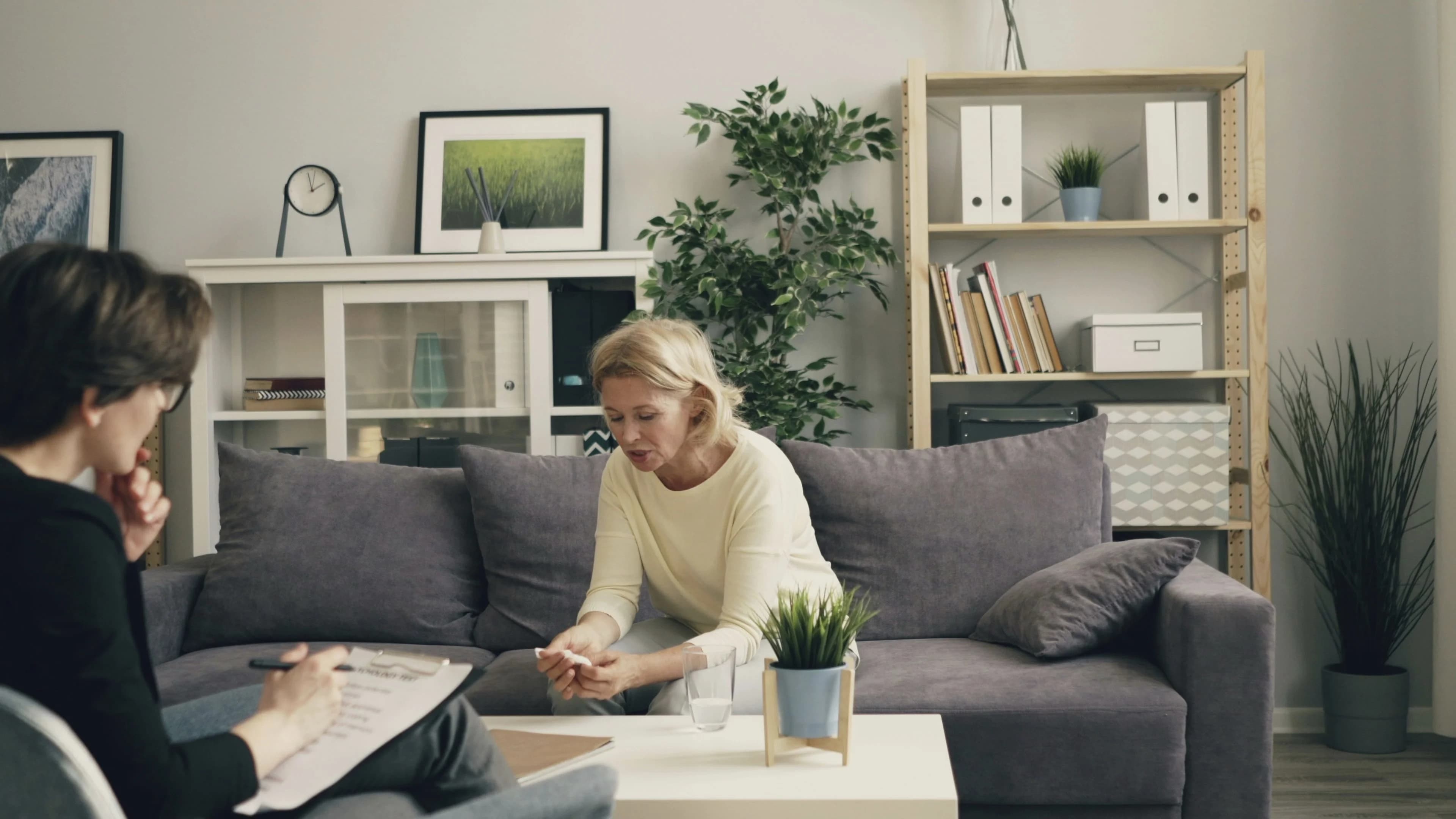 An adult daughter and her elderly father reviewing care paperwork together at a kitchen table before an NHS Continuing Healthcare assessment.