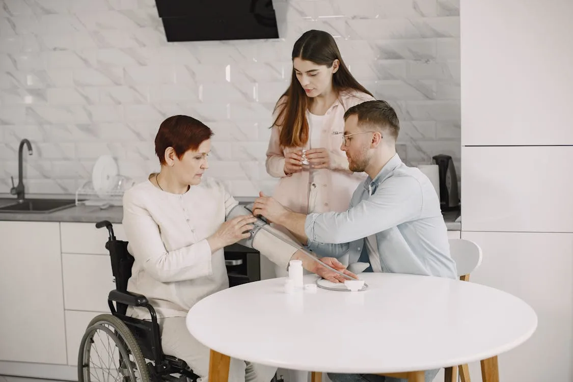 Family members monitoring an elderly woman's blood pressure at home — NHS Continuing Healthcare well-managed needs assessment